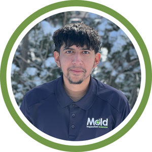 A person with short dark hair and a beard stands outdoors, wearing a navy blue polo shirt with the Mold Inspection Sciences logo. An investigation into natures beauty unfolds as snowy trees blur in the background, framed by a green circle.