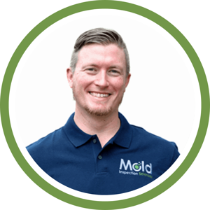 Smiling person wearing a blue polo shirt with Mold Inspection Sciences logo. The image, framed with a green circular border, captures the essence of thorough inspection and commitment to excellence.