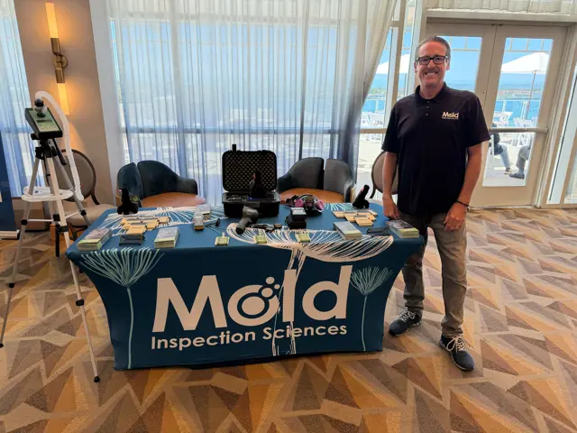 A Mold Inspection Sciences team member with inspection instruments and resources at the BOMA exhibit table.