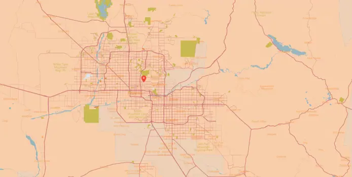 Map showing a detailed view of a city area with highlighted roads and significant locations. A red pin marks a specific point of interest near the center, ideal for inspection. Surrounding areas include natural features like lakes and green spaces.