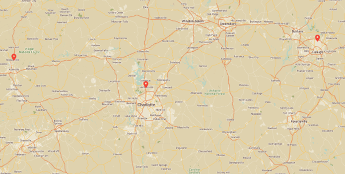 Map of central North Carolina with markers on Asheville, Charlotte, and Raleigh. Highways, cities, and natural landmarks like Pisgah National Forest are visible. The map depicts road networks and terrain details, offering a thorough inspection of the region's geographic layout.