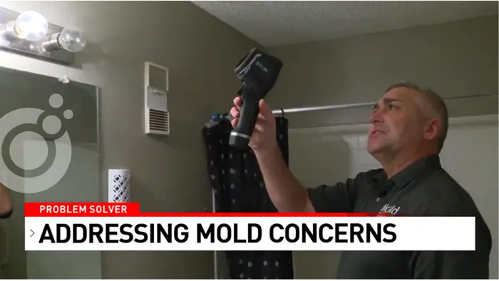 A person stands in a bathroom using a thermal camera for mold assessment. The image features a Problem Solver segment banner with the text Addressing Mold Concerns.
