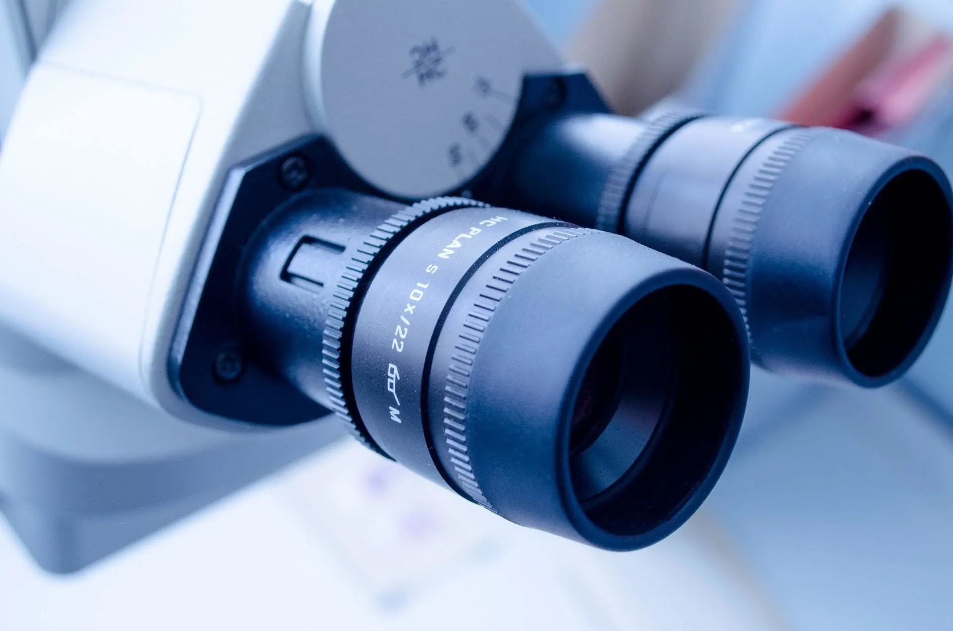 Close-up of a microscope's dual eyepieces, showcasing detailed focus and magnification markings. This image highlights the precision instruments essential for scientific research, testing, and laboratory analysis.